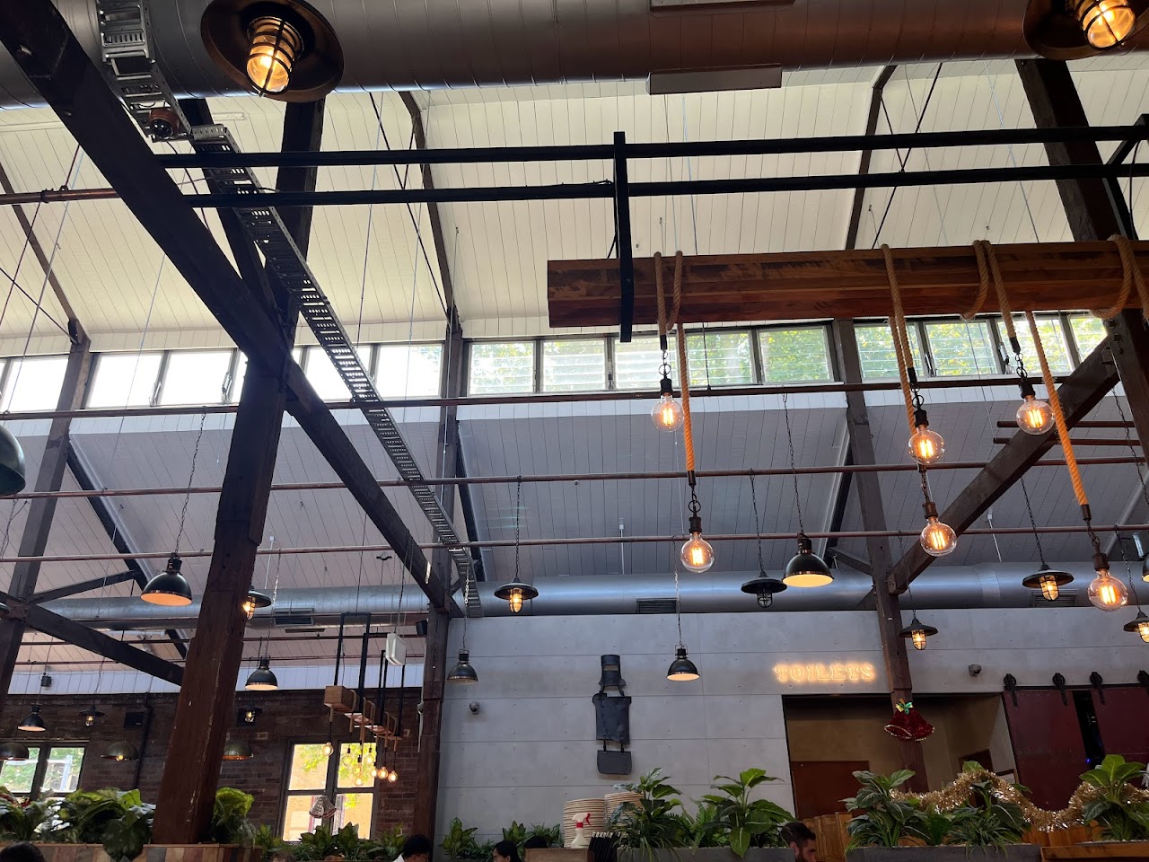 High-ceiling dining room with timber beams and pendant lights